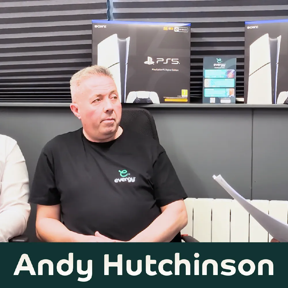 Andy Hutchinson from Evergy seated during a discussion, wearing a branded black t-shirt, with product boxes visible in the background.